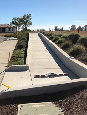 exterior walkway with level and measuring device being inspected for ADA compliance